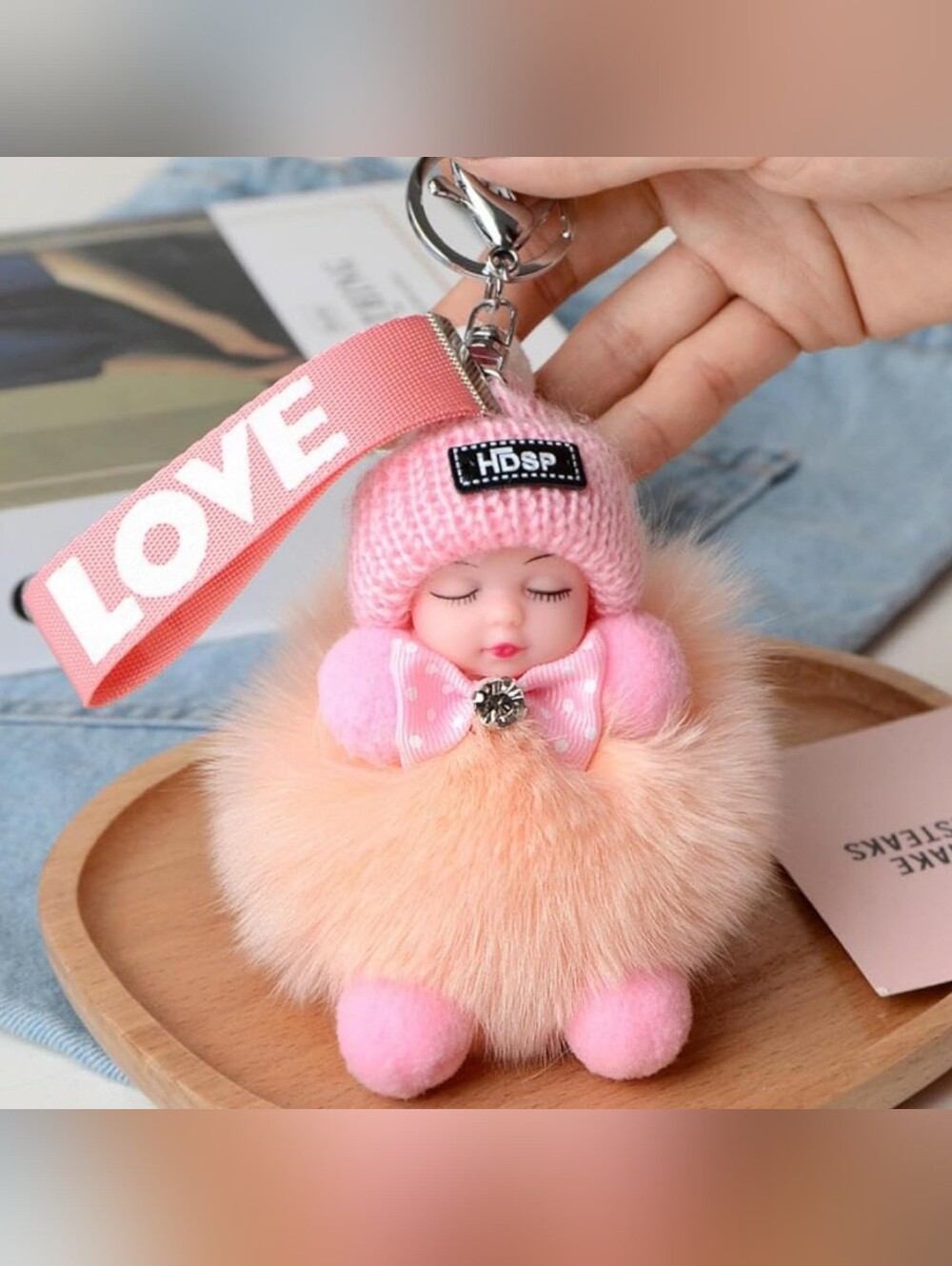 Plush Sleeping Baby Doll Keychain Featuring  a Pompom and "LOVE" Branded Ribbon
